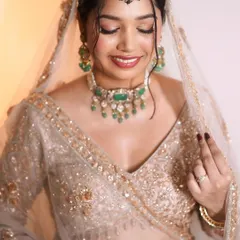 Shining brighter than jewels. This close-up shows the soft, glowing makeup with a hint of shimmer on the eyes, perfectly complementing her pastel outfit and statement jewelry.