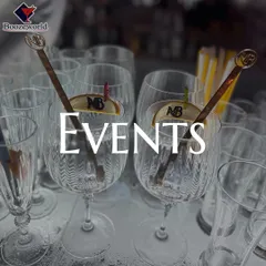 A collection of empty glasses, ready for an event, featuring custom-branded stirrers. We ensure every element of the bar service, down to the smallest detail, reflects your personal style.