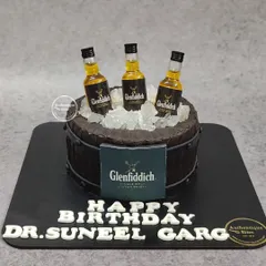 A Glenfiddich barrel cake for a whiskey lover. This non-fondant cake is designed to look like a wooden barrel, topped with miniature Glenfiddich bottles and edible ice cubes.