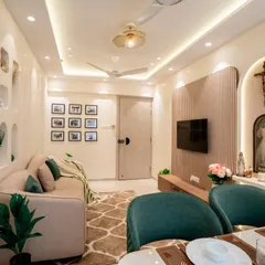 A warm and inviting living space with soft, earthy tones. The design includes a custom wall niche for decor, a comfortable beige sofa, and a dedicated, beautifully lit altar, creating a serene and personal atmosphere.