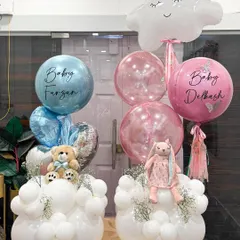 Double the joy for two new arrivals! These matching baby welcome bouquets, one in blue and one in pink, feature personalized balloons, snuggly toys, and fresh florals nestled in a cloud of white balloons.