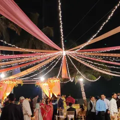 A beautiful canopy of pink and peach drapes interwoven with strings of fairy lights. This lighting creates a warm and festive glow over the entire guest area at this outdoor wedding.