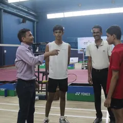A coach provides tactical advice to young players between matches. Our event management includes ensuring that players have access to guidance and support throughout the tournament.