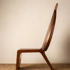 The side profile of the Vismayam chair reveals its sculptural and elegant form. Every curve and line is designed to capture a sense of movement and grace, reflecting the dynamic performance of a Theyyam artist.