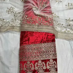 A vibrant red velvet textile, ideal for bridal wear or festive occasions. The fabric is shown with its matching embroidered net, showcasing a complete set for a lehenga or anarkali.