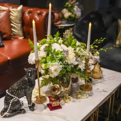 Another angle of the vintage-inspired centerpiece, combining a bold panther statue with delicate pearls, candles, and a fresh floral arrangement.