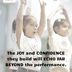 Two young girls reach for the sky in a moment of expressive movement. The joy and confidence they build here will echo far beyond the performance.
