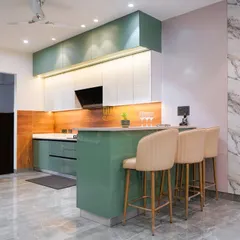 This modular kitchen in Noida is the heart of the home, blending function and style. I used a refreshing green and white color scheme, handle-less cabinetry for a sleek look, and a functional breakfast bar island that makes the space perfect for both cooking and socializing.