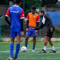 Our certified coaches provide personalized guidance to every player. Here, a coach offers tactical advice during a training drill, focusing on positioning and game awareness to help our young athletes think like pros.