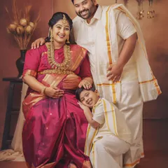 A complete family portrait glowing with happiness. The older brother gently rests his head on his mother's shoulder, a sweet moment captured during their traditional maternity photoshoot.