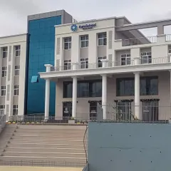 The main elevation of the completed EuroSchool building at Hesaraghatta Main Road. This view highlights the blend of contemporary design, with its clean lines and glass curtain wall, and classical elements like the pillared entrance, creating an imposing and welcoming institutional structure.