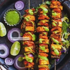 Our Paneer Tikka skewers feature soft paneer cubes marinated in spices and grilled with bell peppers and onions. This popular North Indian appetizer is a vibrant and flavorful start to any celebration.