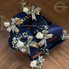 Unwrap the beauty of travel with our stunning hamper. This set features a complete collection of personalized navy blue travel essentials, elegantly decorated with white roses and baby's breath.