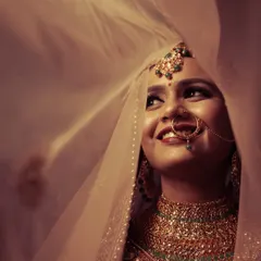 The timeless beauty of a bride, captured in a moment of quiet joy. This portrait, with the delicate veil and soft lighting, is an example of how we create elegant and emotional bridal shots that you will cherish forever.
