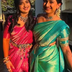 A lovely photo of the two sisters together, showcasing their coordinated outfits. My group draping service ensures that everyone in the family can have a consistent and polished look for the wedding.