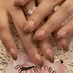 A moody and sophisticated ombre on long, almond-shaped nails. This set features a beautiful gradient from a sheer nude base to a deep brown at the tips.