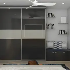 This bedroom features a sleek, wall-to-wall sliding wardrobe with glossy black and grey panels. Next to it, we added a cozy reading nook with a built-in bench and bookshelves, demonstrating our ability to combine storage with comfort.
