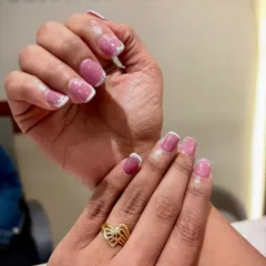 A beautiful blend of classy and glam. This look features a soft mauve base with a delicate glitter fade and a crisp white French tip.