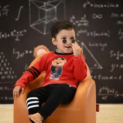 A playful shot of the young boy adjusting his glasses, full of personality and charm.