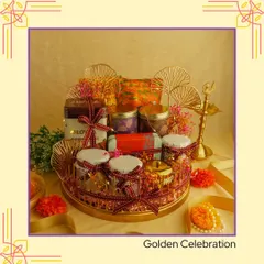 An example of a "Golden Celebration" hamper for Diwali. This arrangement features a golden tray filled with jars of goodies and adorned with decorative fans, creating a truly luxurious festive gift.
