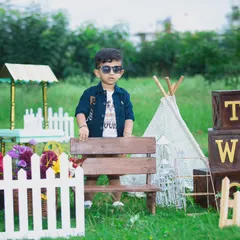 This little guy is looking very stylish for his outdoor photoshoot, posing confidently in his sunglasses.