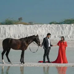 A fairytale moment from a pre-wedding shoot in Jaipur, where the couple shares a quiet connection with a horse by the water, creating a scene that is both grand and intimate.