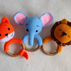 Three of my animal rattle toys: a fox, an elephant, and a lion. They are made with wooden rings that are safe for babies to chew on.
