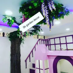 A creative installation of an artificial tree that appears to grow indoors and spread its branches across the ceiling. This was done for a child's playroom to create a magical forest theme.