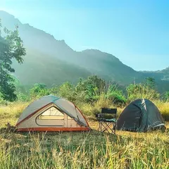 A simple, sun-drenched campsite in the foothills. This setup is perfect for a relaxed weekend, soaking in the morning sun and breathing in the fresh air with a beautiful mountain range in the background.