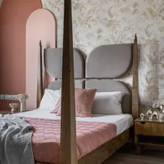 For this daughter's bedroom, we designed a custom four-poster bed with a unique, wing-shaped headboard. The color palette of soft pinks and greys, paired with a subtle botanical wallpaper, creates a room that is whimsical, elegant, and fit for a princess.