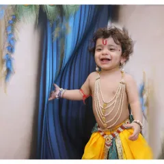 A happy, candid moment during a Krishna-themed session. We encourage play and movement to capture genuine smiles and the joyful spirit of your child.