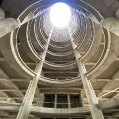 A view looking up from the base of the Sant Nirankari Hospital atrium during construction. This image reveals the raw structure that creates the soaring, light-filled space designed to enhance ventilation and openness.