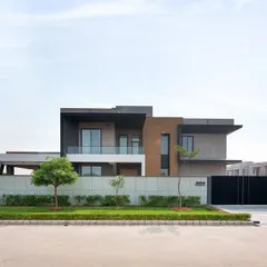 The front elevation of the Sonipat residence, showcasing its clean lines, cantilevered volumes, and a material palette of concrete and wood.