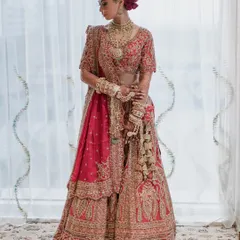 A classic full-length portrait of the bride in her magnificent red and gold lehenga, radiating timeless elegance.