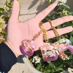 My custom initial keychains are perfect for gifting or for yourself. Here you can see a set made for a group, each with a unique name and color combination. I can personalize these with different colors, glitters, and names.