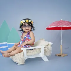 A day at the beach, right here in my studio. This little girl is ready for sun and sand, lounging on a miniature beach chair with surfboards and a parasol.