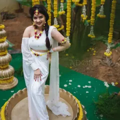 The bride is ready for her Haldi ceremony, seated in a traditional urli decorated with yellow flowers. We ensure every detail, including the floral jewelry and seating, aligns with the overall theme.