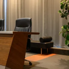 A detail shot of the custom conference table. The dynamic angled leg is finished in a warm veneer, contrasting with the sleek tabletop. It’s a small detail that adds a lot of character to the room.