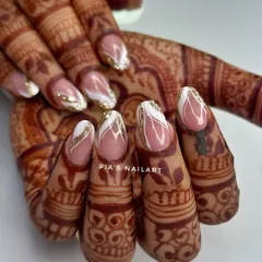 Elegance is in the details. This bridal set, shown against beautiful henna, features a delicate white and gold glitter design over a soft nude base, creating a look that is both intricate and sophisticated.