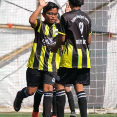Teamwork makes the dream work. A high-five between our Young Guns players after a successful play, embodying the spirit of our academy.