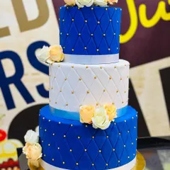 We love creating elegant designs like this 7kg, three-tiered cake. It features a sophisticated royal blue and white fondant with a quilted pattern, gold bead detailing, and is topped with beautiful handmade sugar roses, perfect for weddings, anniversaries, or grand birthday celebrations.