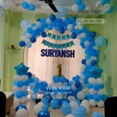 A beautiful blue and white theme for Suryansh's first birthday. This indoor setup features a balloon arch, star-topped pillars, and a personalized banner, showing how we can transform a home space for a celebration.