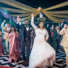This is what a celebration looks like! The bride and groom leading their guests on the dance floor, with everyone's hands in the air. I aim to capture the collective joy of your wedding reception.