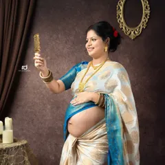 A classic pose showing the mom-to-be admiring her baby bump in a handheld mirror. This shot beautifully captures the joy and wonder of pregnancy in a traditional setting.