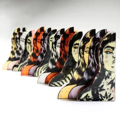 'Confrontation,' a mixed-media piece combining illustrated paper cutouts with ceramic slab-ware. The work explores layers of the self and the female gaze.