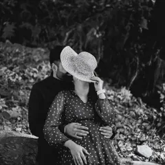 A playful and artistic black and white photo. The hat adds an element of mystery and fun, creating a unique composition that is both romantic and stylish.