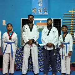 A group photo of our students after a successful belt promotion test. This picture includes students with new blue and red belts, standing proudly with their instructors.