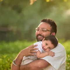 A quiet, tender moment as a son rests his head on his father's shoulder. It's not just about the big laughs; I also capture the gentle, loving connections.