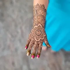 A full mandala session, with a large, detailed flower mandala on the palm and a matching cuff design on the wrist.