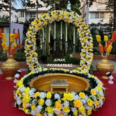 This Haldi setup is all about traditional elegance. I designed a circular floral arch using yellow and white flowers around a classic 'urli', creating a beautiful focal point for the ceremony on the red-carpeted lawn.